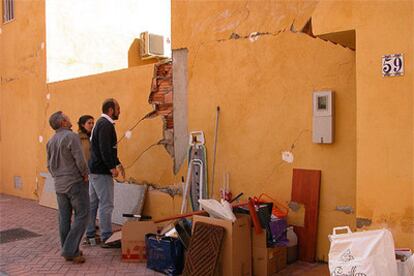 Un grupo de vecinos observa los daños en las paredes de sus casas de Vícar.