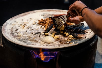 El jefe de cocina de Pujol, Alex Bremont  tuesta los ingredientes en un comal de barro.
