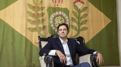 Luiz Philippe de Orléans e Bragança, diante de uma bandeira do período imperial, em seu apartamento.