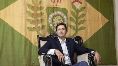 Luiz Philippe de Orléans e Bragança, diante de uma bandeira do período imperial, em seu apartamento.