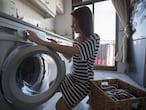 Mujer pone una lavadora en su domicilio en Madrid, el 8 de marzo de 2021.