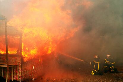 Bomberos trabajan para apagar las llamas que devoran las tiendas de campaña en el campamento de Calais.