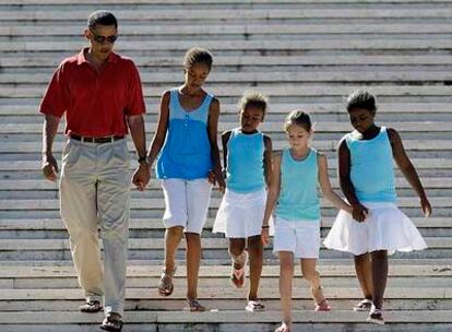 Obama desciende del monumento del cementerio nacional de Honolulú con sus hijas (las dos primeras por la izquierda) y unas amigas de éstas.