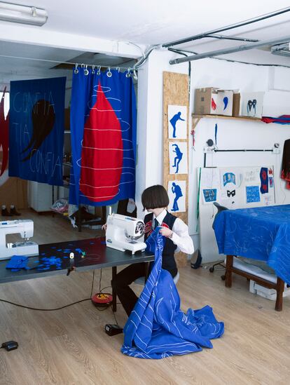 Gema Polanco borda con la máquina de coser que le regaló su abuela en su taller rodeada de algunas de sus últimas piezas.