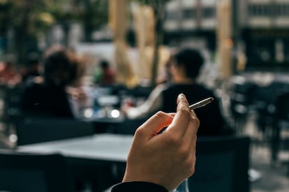 Un joven fuma en una terraza del centro de Santiago, este viernes.