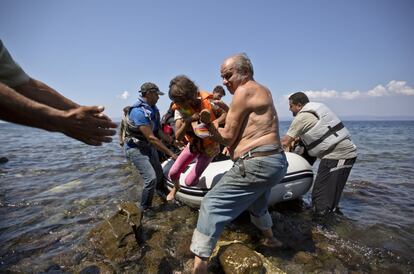 Un habitant de l'illa grega de Lesbos ajuda un nen sirià en el moment de la seva arribada en un pot al poble de Sikaminies. Més de 160.000 refugiats han arribat aquest any a les illes del mar Egeu.