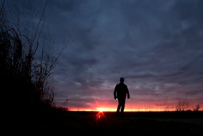 In this Nov. 20, 2015 file photo, a man walks along a trail during sunset near Manhattan, Kan