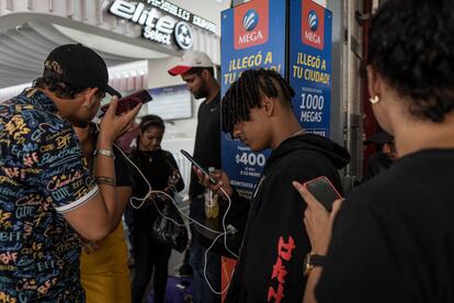 Migrantes centroamericanos cargando sus celulares en la Central de Autobuses del Norte, en Ciudad de México.