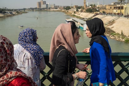 Women stand on the "martyrs' bridge" spanning the Tigris River in Baghdad, Iraq, Friday, Feb. 24, 2023.