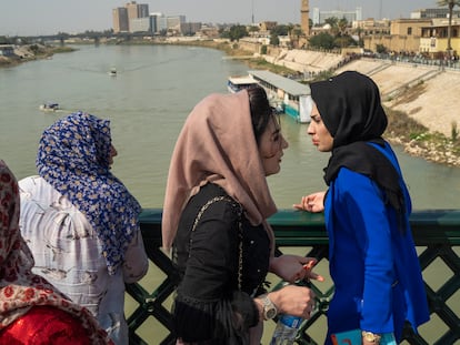 Women stand on the "martyrs' bridge" spanning the Tigris River in Baghdad, Iraq, Friday, Feb. 24, 2023.