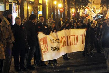 Centenares de personas realizan una cadena humana alrededor del Banco de España para protestar por la reforma de las pensiones.