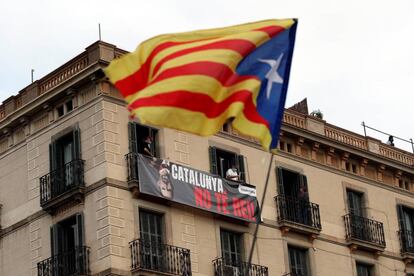 Unos vecinos colocan una pancarta de protesta por la presencia del Rey en Cataluña en las inmediaciones de la estación de Francia de Barcelona.