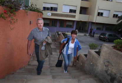 An evacuated German couple leaving a student residence in Valverde after spending the night there.