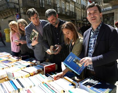 El secretario general del PSdG, Gonzalo Caballero (primero por la derecha), compra unos libros en un puesto callejero en Santiago de Compostela, acompañado por miembros de la dirección del Partido Socialista gallego.