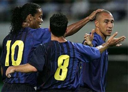 Ronaldinho y Giuly felicitan al sueco Larsson, autor de dos goles.