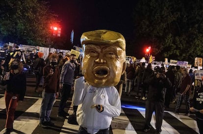 Un hombre usa una cabeza gigante de Trump, mientras los manifestantes se reúnen cerca de la Casa Blanca en Washington, DC.