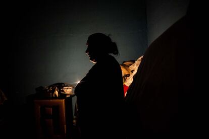 María, vecina del sector 6 de Cañada Real, sujeta una vela para poder iluminar  el interior de su vivienda llena de mantas para poder soportar las gélidas  temperaturas ante  la falta de electricidad.