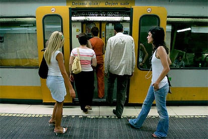 Varias personas suben al metro a primeras horas de la mañana en la reabierta estación de Jesús de la línea 1 de Valencia.