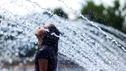 Una ciudadana se refresca en una fuente de agua en el paseo marítimo de Georgetown en Washington, DC.