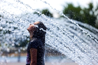 Una ciudadana se refresca en una fuente de agua en el paseo marítimo de Georgetown en Washington, DC.
