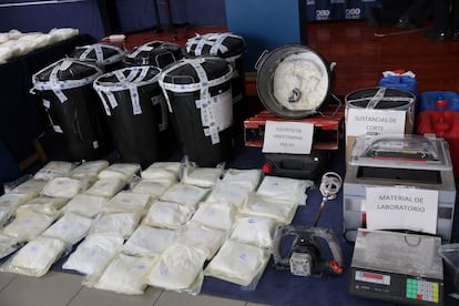 A la izquierda, los cubos de basura en los que la organización fabricaba el 'speed', sellados con precinto policial, y en el centro uno de ellos, volcado, en el el que se puede apreciar parte del sulfato de anfetamina, una de las palas que supuestamente usaban para rellenar las bolsas, y diferentes utensilios del laboratorio.
