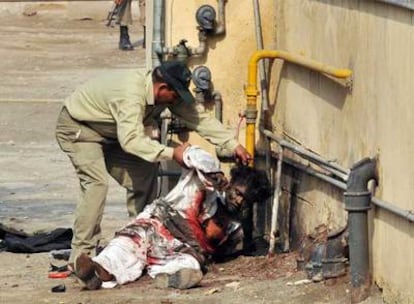 Un especialista en desactivación de explosivos inspecciona el cuerpo sin vida de uno de los atacantes de la Agencia Federal de Investigación en Lahore.