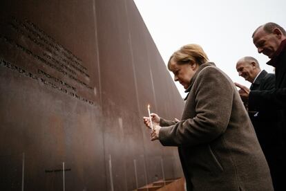 A chanceler alemã Angela Merkel acende uma vela em frente ao memorial durante o 30º aniversário da queda do muro.