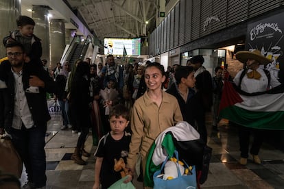 Entre aplausos y el canto de consignas, Amir y Alma Abed caminan por el Aeropuerto Internacional de Ciudad de México, la madrugada de este sábado. 