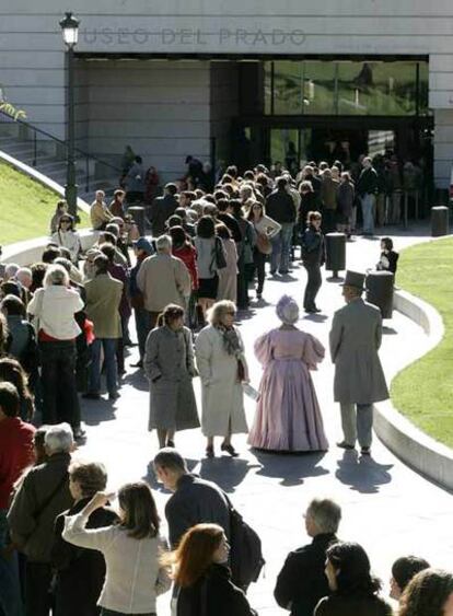 Dos figurantes vestidos de época pasean entre las personas que hacen cola para visitar las nuevas instalaciones del Museo del Prado, estrenadas ayer.