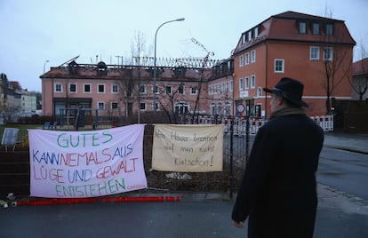 Um homem diante de faixas de protesto contra o incêndio de um hotel, na segunda-feira em Bautzen (Alemanha).