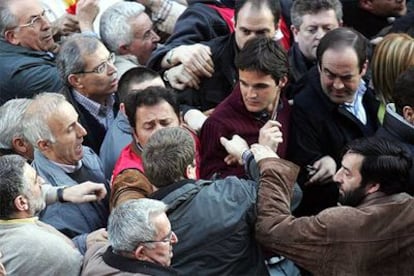 El ministro de Defensa, José Bono (a la derecha), y su hijo, durante los incidentes registrados en la manifestación del sábado en Madrid.