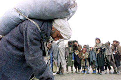 Un afgano transporta un saco con carbón procedente de la ayuda internacional en la ciudad de Mazar-i-Sharif.