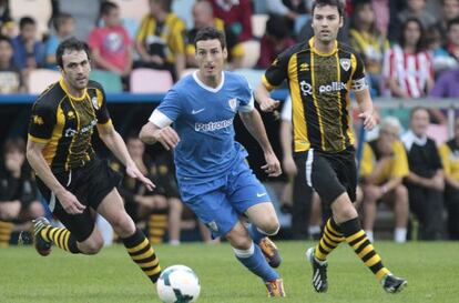 El delantero del Athletic Aritz Aduriz, en el centro, pelea un balón con dos jugadores del Barakaldo en el partido amistoso disputado en Lasesarre.