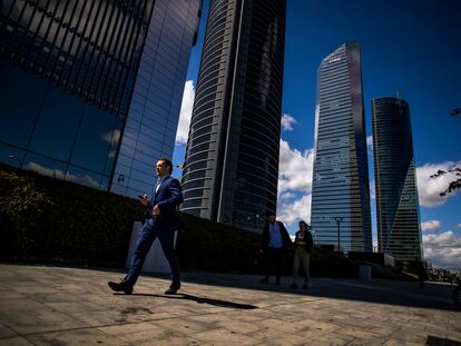 Un hombre con traje pasea por la zona la de las cuatro torres del Paseo de la Castellana, en Madrid, en 2019.