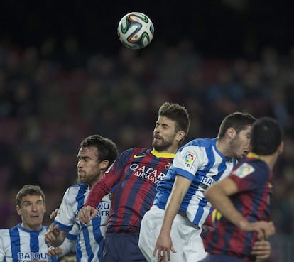 El defensa del FC Barcelona Gerard Piqué (c) salta entre varios jugadores de la Real Sociedad, durante el partido de ida de la semifinal de la Copa del Rey que disputan esta noche en el Camp Nou, en Barcelona. 