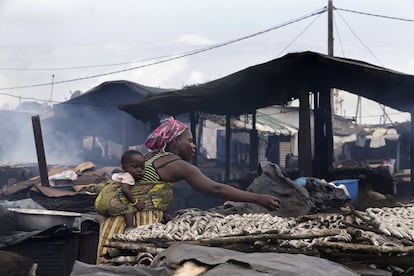 Una mujer prepara pescado para ser ahumado en un mercado de Abiyán, Costa de Marfil.