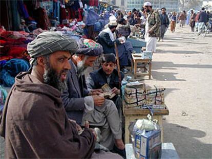 Cambiadores de dinero, con fajos de billetes de afagnis, en una calle de Kabul.