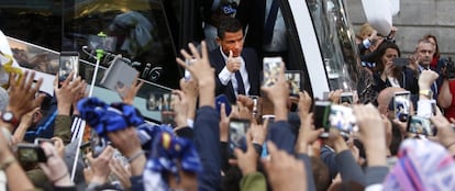 Cristiano Ronaldo saluda a los aficionados que esperan la llegada del equipo blanco a la Puerta del Sol.