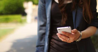 Una mujer utiliza un teléfono movil. 