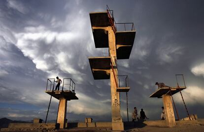 Un grupo de niños juega sobre los trampolines de una piscina vacía en Kabul, el 5 de junio de 2007. Los talibanes prohibieron durante su gobierno las piscinas, las cometas y la música.