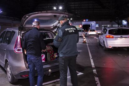 Un agente de la Guadia Civil registra un vehículo en la aduana.