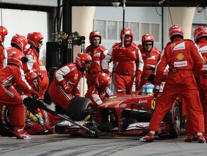 Fernando Alonso, con sus mecánicos en boxes.