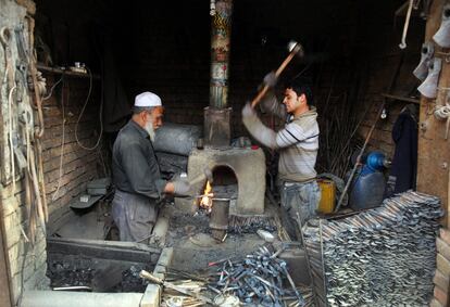 Padre e hijo trabajan en una herrería en Kabul (Afganistán), el 9 de febrero de 2016.