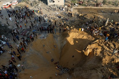 Decenas de palestinos rodeaban un cráter provocado por una bomba israelí en Jan Yunis, franja de Gaza, este lunes. 