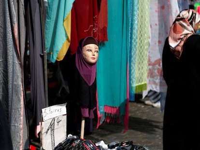 Una mujer con velo islámico pasa por delante de una tienda que vende hiyabs en el barrio bruselense de Molenbeek.