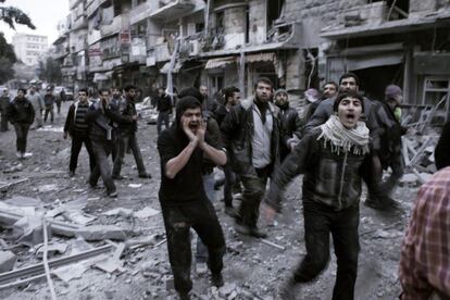 Ciudadanos sirios gritan consignas mientras se acercan al edificio blanco de un misil en Alepo. Las Naciones Unidas recientemente han denunciado una "proliferación de delitos graves, incluidos los crímenes de guerra" en Siria.