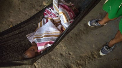Una mujer waorani vigila a un bebé mientras éste duerme en una hamaca. Al inicio del proyecto los hombres waorani estaban "molestos", pero los ancianos reconocieron que debían caminar hasta un día por la selva para poder cazar los animales que vendían para el sustento familiar.