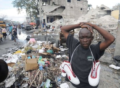 Un hombre haitiano vende zapatos usados en Puerto Pr&iacute;ncipe
 