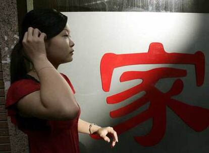Ye Xia (Elena), una joven china de 19 años, tras colocar las letras de su nuevo negocio, Casa de Vinos.