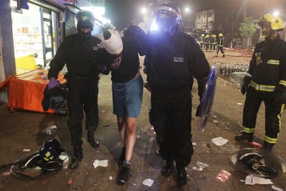 Policías antidisturbios conducen a un detenido por las calles de Tottenham.
